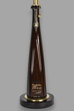 Liquor bottle lamp made from a reclaimed Don Julio 1942 Tequila bottle, close-up view, on a gray background