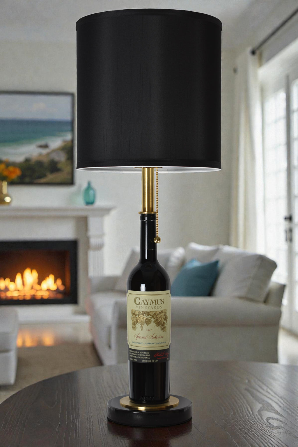 Wine bottle lamp made from a reclaimed 2017 Caymus Cabernet Sauvignon bottle, full view, light off, in a cozy living room
