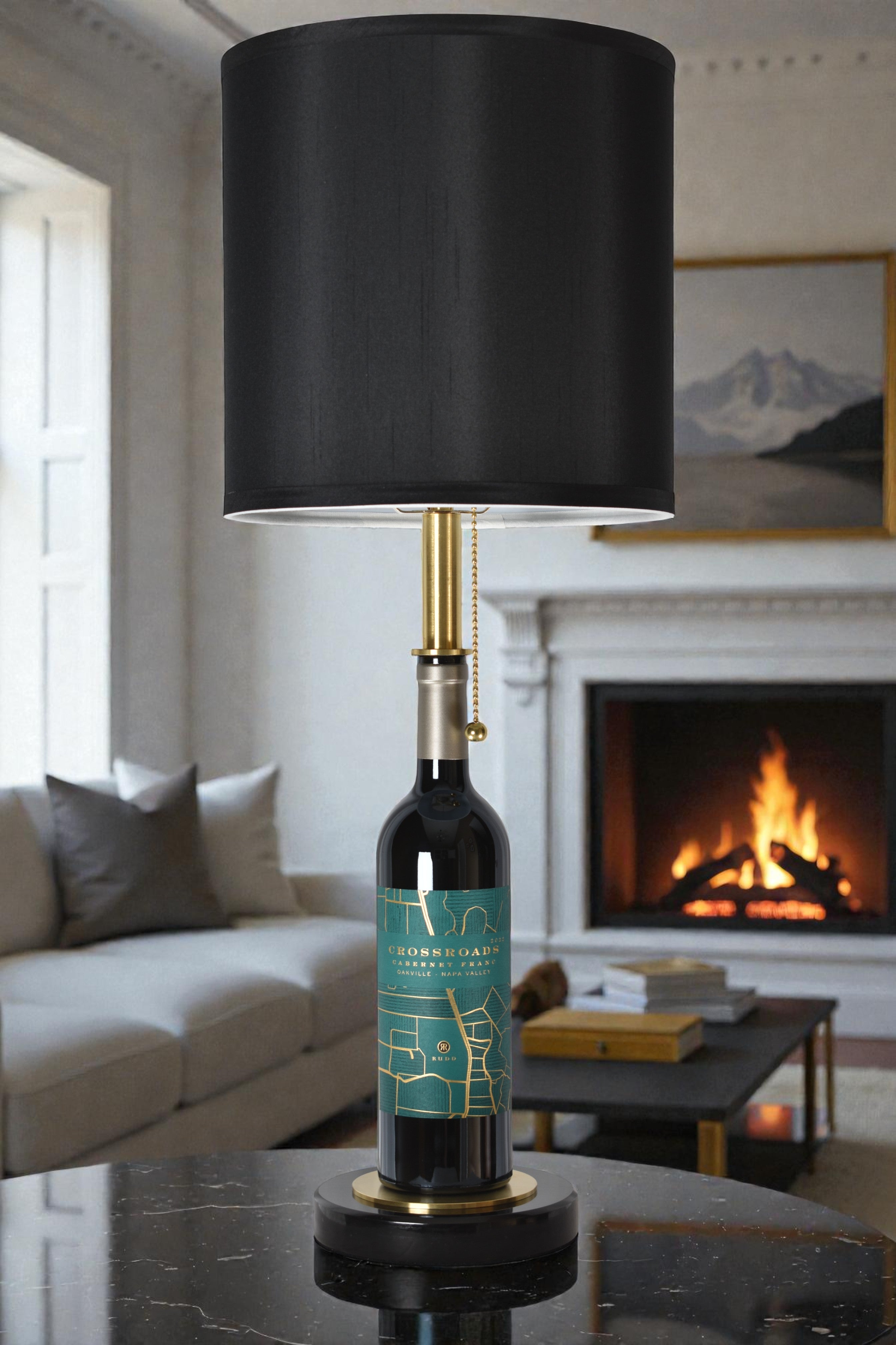 Wine bottle lamp made from a reclaimed 2022 Crossroads Cabernet Franc bottle, full view, light off, in a cozy living room