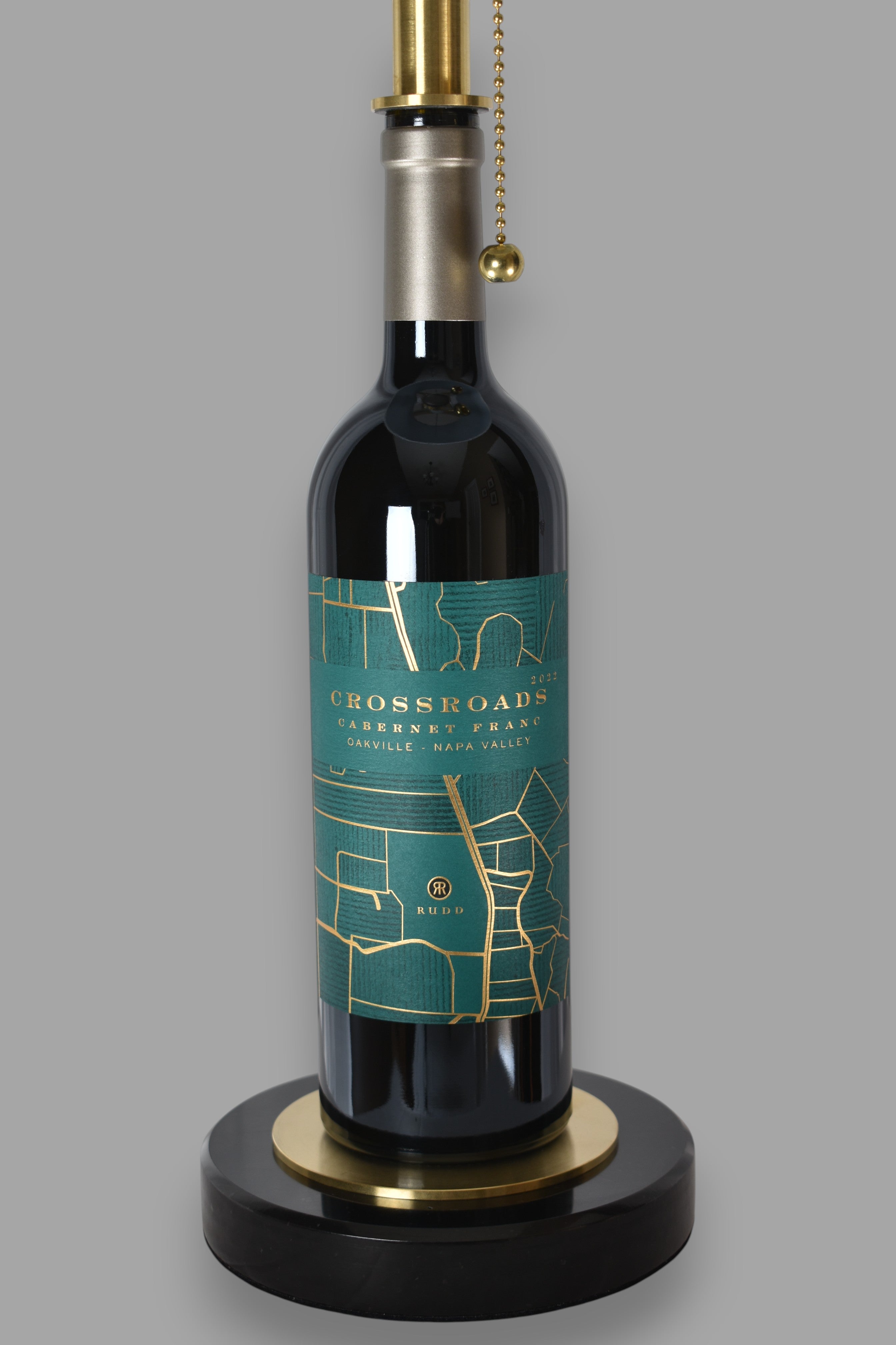 Wine bottle lamp made from a reclaimed 2022 Crossroads Cabernet Franc bottle, close-up view, on a gray background