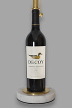 Wine bottle lamp made from a reclaimed 2022 Decoy Cabernet Sauvignon bottle, close-up view, on a gray background