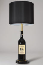 Wine bottle lamp made from a reclaimed 2016 Duckhorn Magnum Cabernet Sauvignon bottle, full view, light off, on a gray background