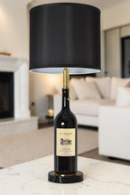 Wine bottle lamp made from a reclaimed 2016 Duckhorn Magnum Cabernet Sauvignon bottle, full view, light off, in a cozy living room