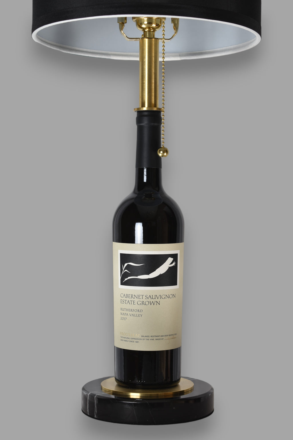 Wine bottle lamp made from a reclaimed 2017 Frog's Leap Cabernet Sauvignon bottle, front view, on a gray background