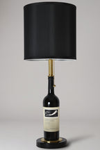Wine bottle lamp made from a reclaimed 2017 Frog's Leap Cabernet Sauvignon bottle, full view, light off, on a gray background