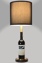 Wine bottle lamp made from a reclaimed 2017 Frog's Leap Cabernet Sauvignon bottle, full view, light on, on a gray background