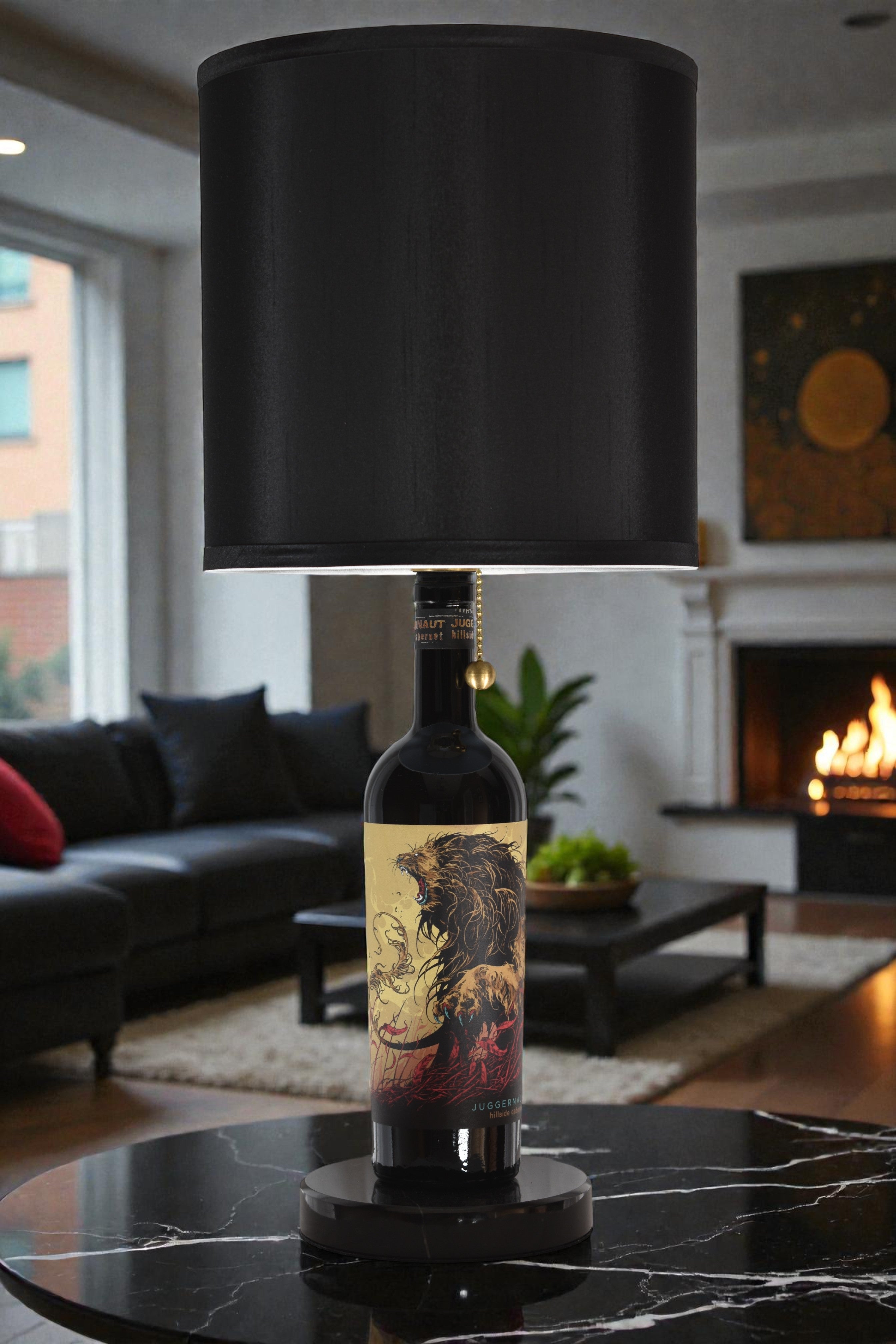 Wine bottle lamp made from a reclaimed Juggernaut Cabernet Sauvignon bottle, full view, light off, in a cozy living room