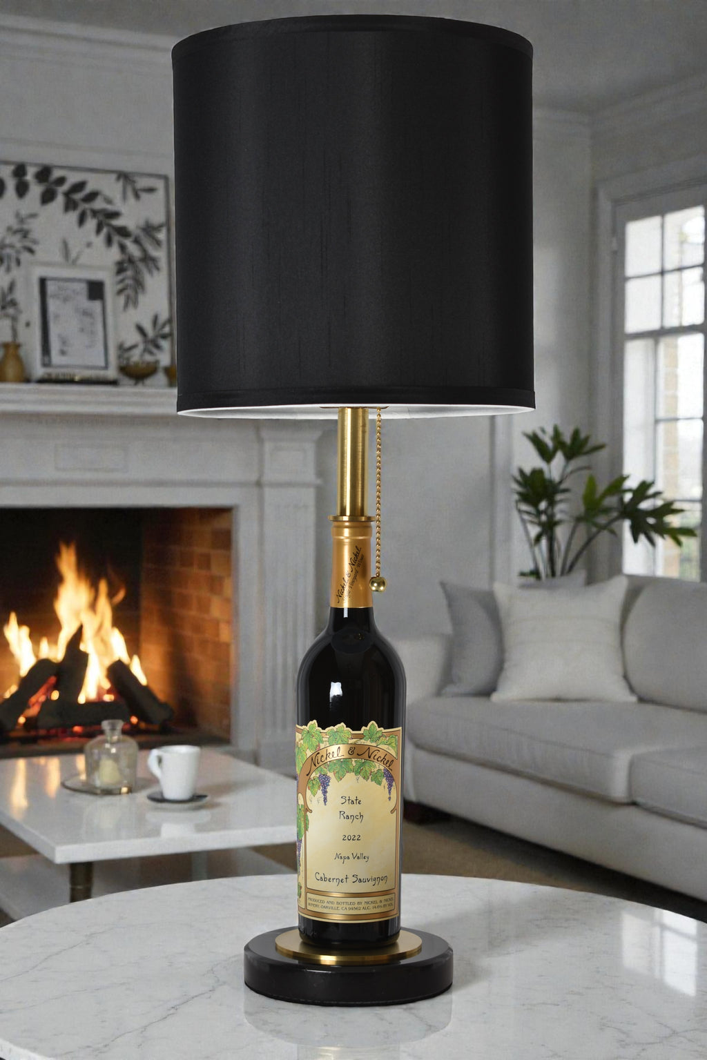 Wine bottle lamp made from a reclaimed 2022 Nickel & Nickel Cabernet Sauvignon bottle, full view, light off, in a cozy living room