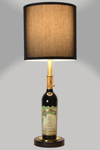 Wine bottle lamp made from a reclaimed 2022 Nickel & Nickel Cabernet Sauvignon bottle, full view, light on, on a gray background