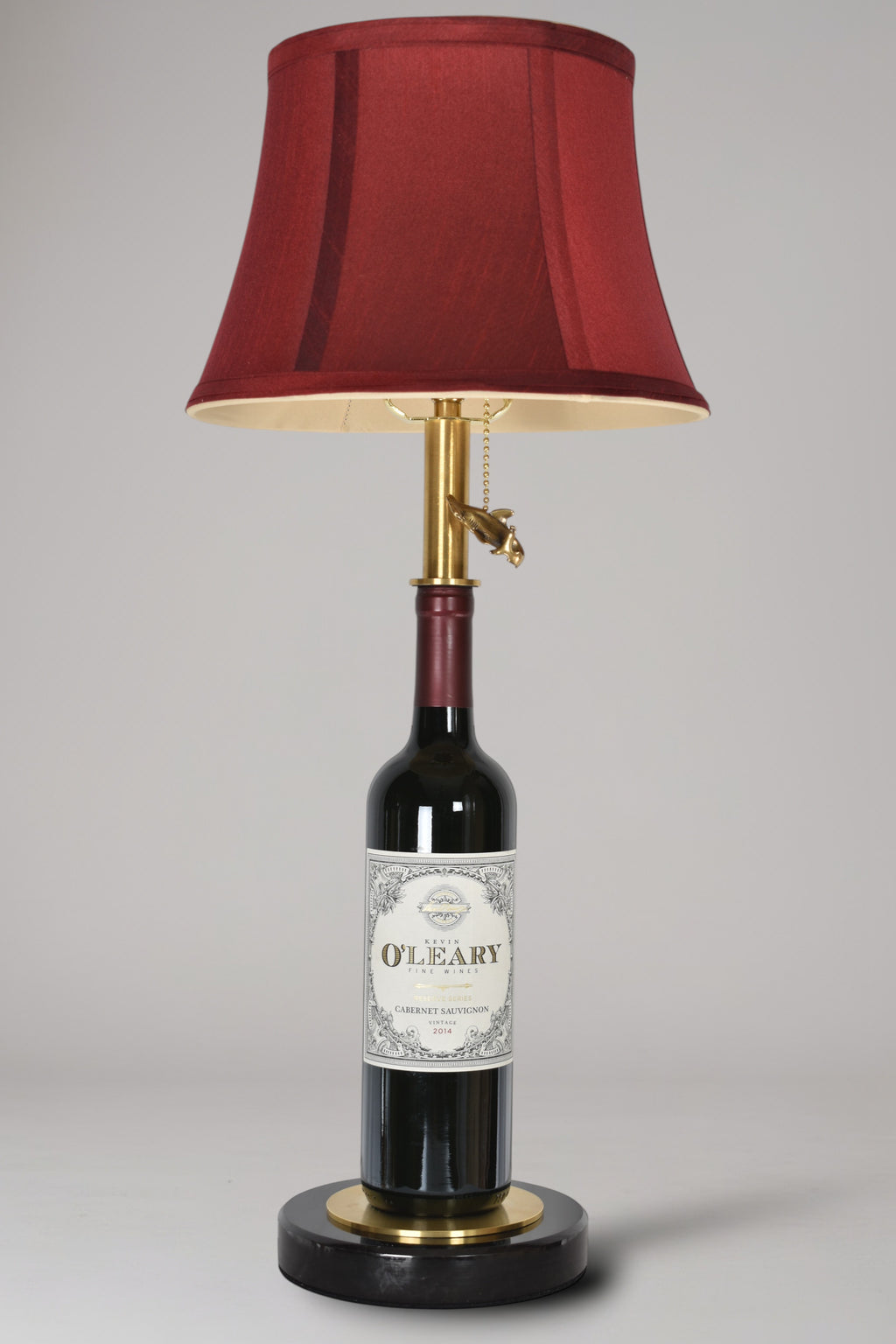 Wine bottle lamp made from a reclaimed 2014 O'Leary Cabernet Sauvignon bottle, full view, light off, on a gray background