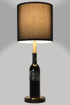 Wine bottle lamp made from a reclaimed 2021 Paul Hobbs Cabernet Sauvignon bottle, full view, light on, on a gray background