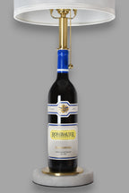 Wine bottle lamp made from a reclaimed 2023 Rombauer Zinfandel bottle, front view, on a gray background