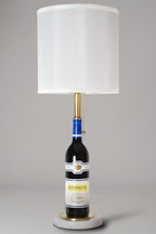 Wine bottle lamp made from a reclaimed 2023 Rombauer Zinfandel bottle, full view, light off, on a gray background