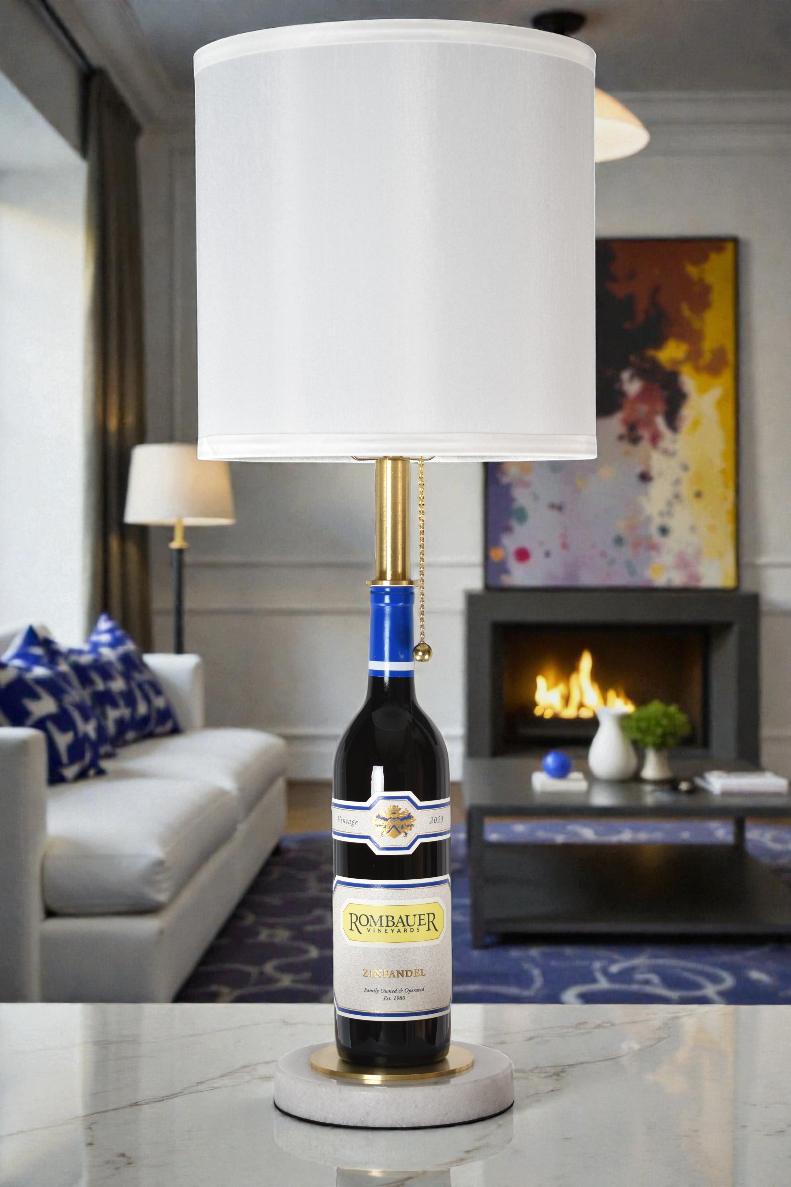 Wine bottle lamp made from a reclaimed 2023 Rombauer Zinfandel bottle, full view, light off, in a cozy living room
