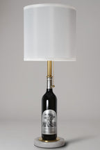 Wine bottle lamp made from a reclaimed 2020 Silver Oak Cabernet Sauvignon bottle, full view, light off, on a gray background