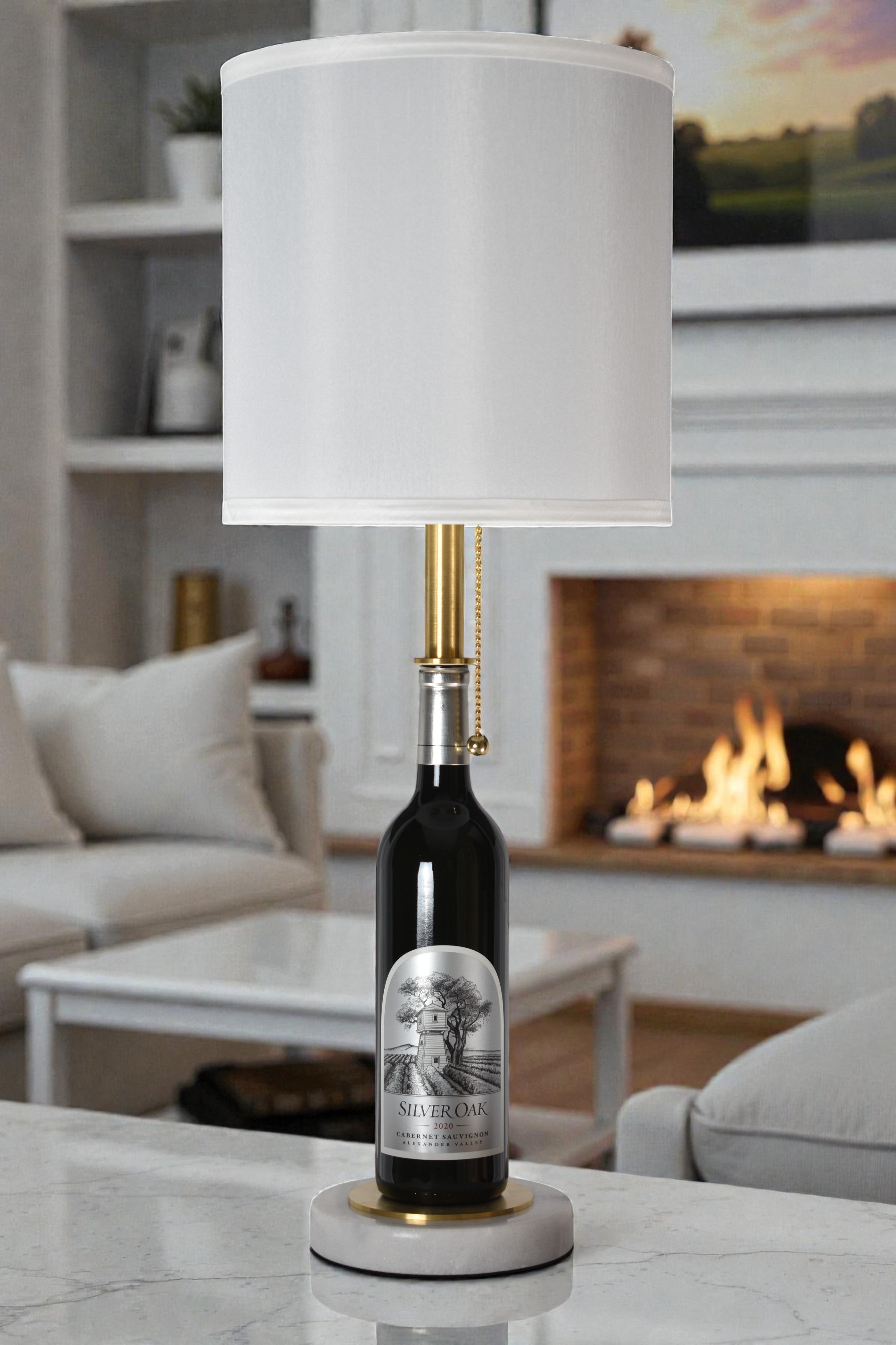 Wine bottle lamp made from a reclaimed 2020 Silver Oak Cabernet Sauvignon bottle, full view, light off, in a cozy living room