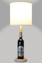Wine bottle lamp made from a reclaimed 2020 Silver Oak Cabernet Sauvignon bottle, full view, light on, on a gray background